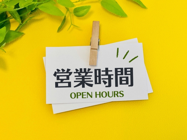 黄色い背景に「営業時間」の文字と緑の葉