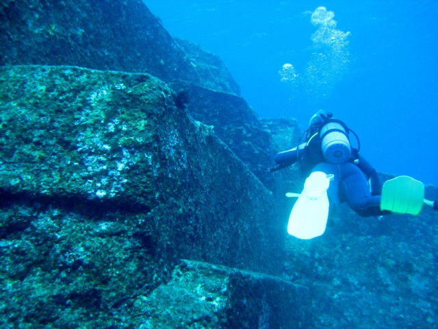 与那国島海底遺跡のダイビングポイントを探索するスキューバダイバーの後ろ姿。